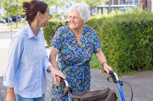 Dames met rollator op de stoep