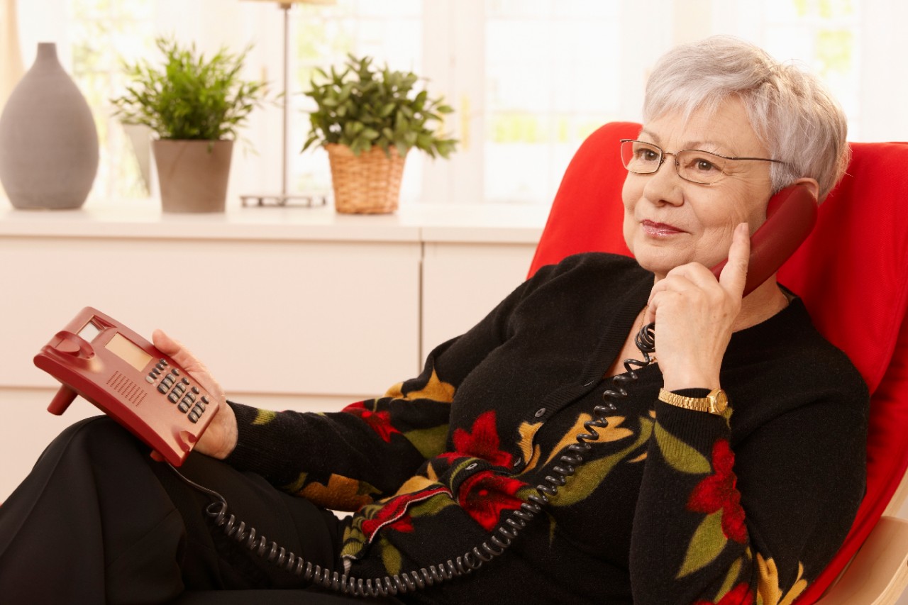 Bellende mevrouw op een rode stoel