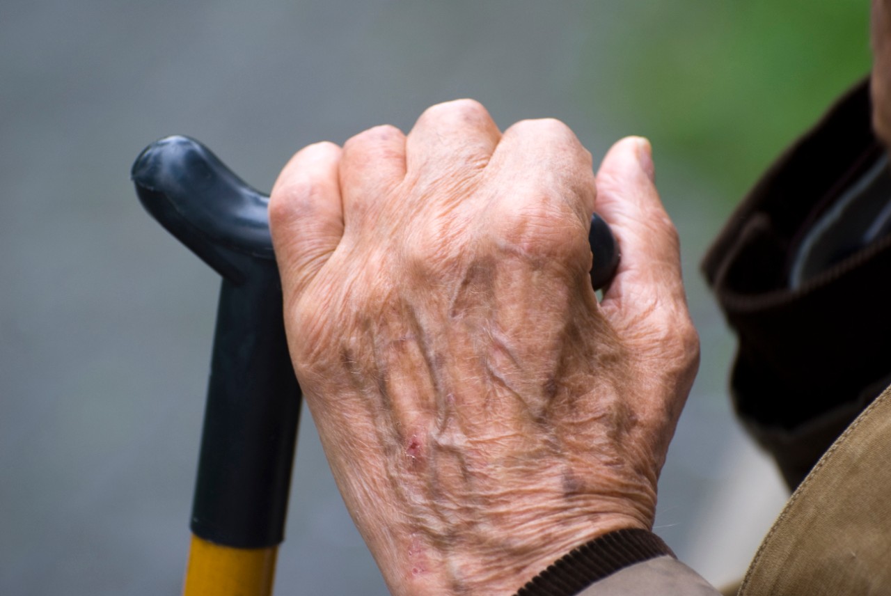 Oudere heer leunt op zijn wandelstok