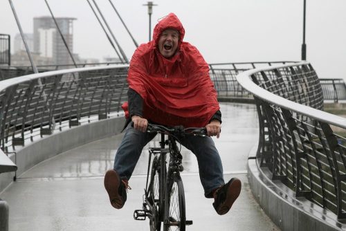 Meneer op herenfiets in de regen