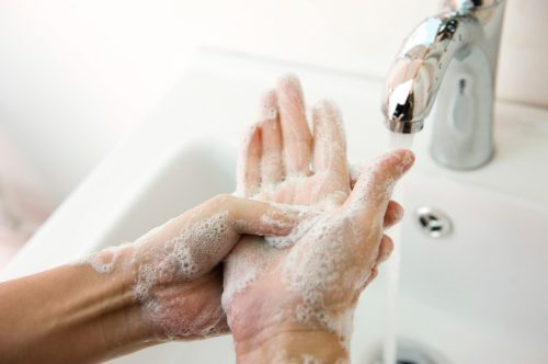 Handen wassen onder de wastafelkraan