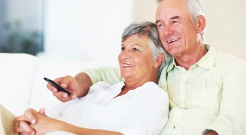 Meneer en mevrouw kijken tv op de bank