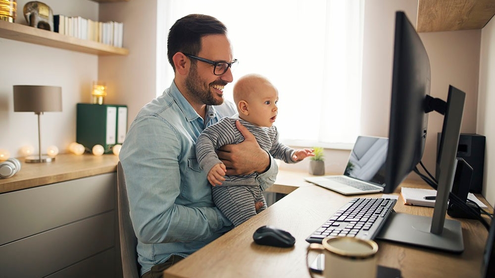 Vader werkt thuis met babyzoontje