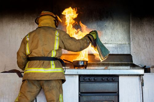 Brandweerman dooft vlam in de pan met een blusdeken