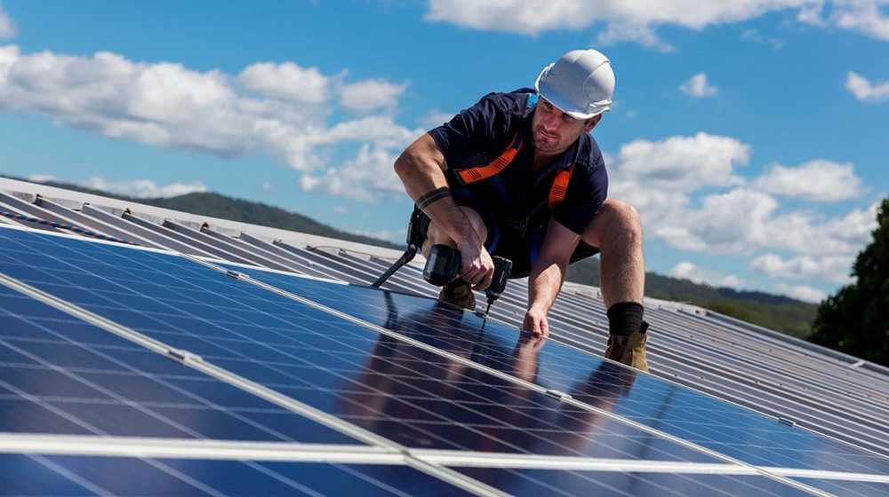 Installateur installeert zonnepanelen op een dak