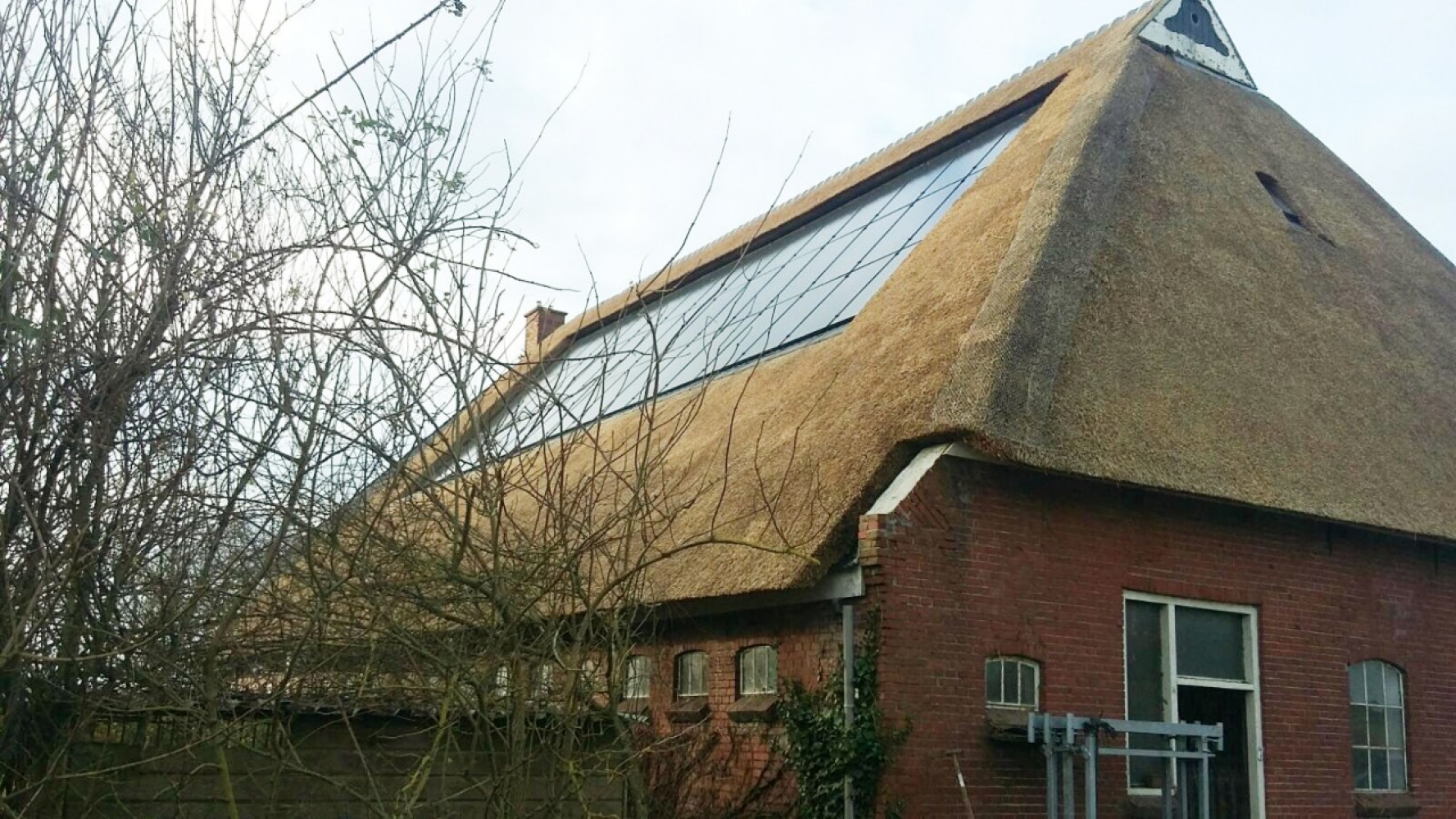 Zonnepanelen op een rieten dak